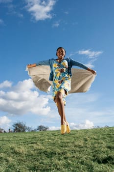 young woman running with a blanket behind her