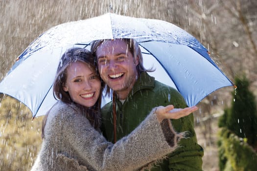 Young couple enjoying the rain under an umbrella