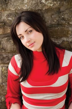 Close up portrait of an attractive young woman sitting outside smiling for the camera