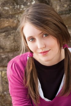Close up portrait of an attractive young woman sitting outside smiling for the camera