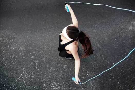 Girl in activewear exercising with skipping-rope