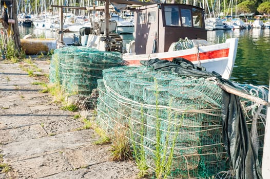 Fishing creels on the pier in the background fishing boat