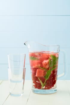 Flavoured water or infused water with watermelons,red currants and mint in a carafe