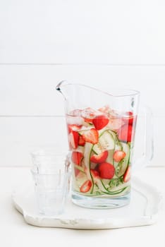 Flavoured water or infused water with cucumbers,strawberries and thyme in a carafe