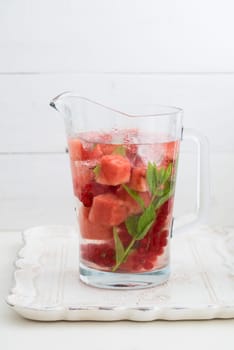 Flavoured water or infused water with watermelons,red currants and mint in a carafe