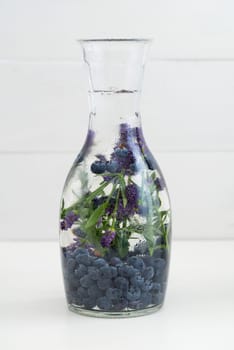 Flavoured water or infused water with blueberries and lavender in a carafe