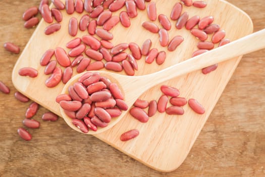 Raw red kidney bean on wooden table, stock photo