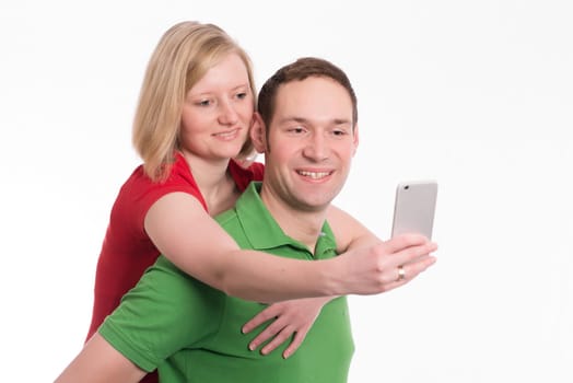 young couple in front of white background take self-portrait with phone