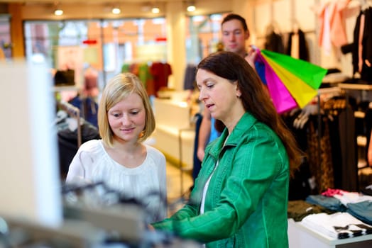 two women and a man in the clothes shop looking for outfit