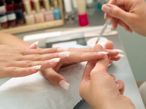 Girl fingernails being manicured.