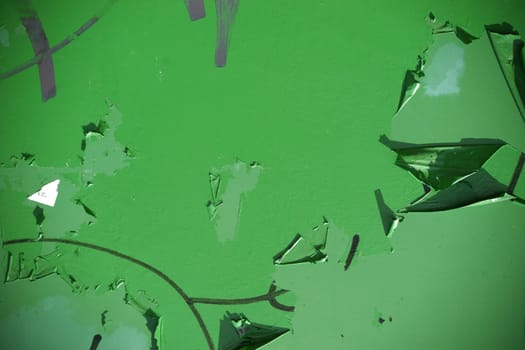 The close-up of a peeling paint layer or rust protection paint on a metal substrate.