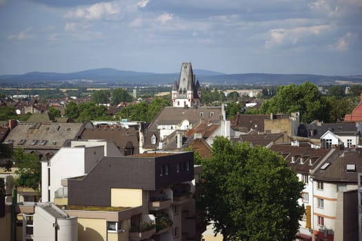 A view over residential complexes and residential buildings in the city of Mainz with the top of the iron tower.