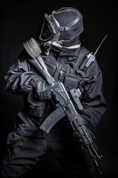 Russian special forces operator in black uniform and gas mask