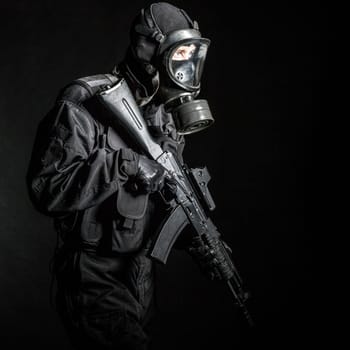 Russian special forces operator in black uniform and gas mask