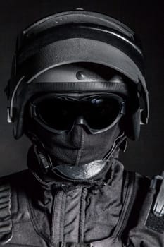 Russian special forces operator in black uniform and bulletproof helmet