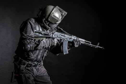 Russian special forces operator in black uniform and bulletproof helmet