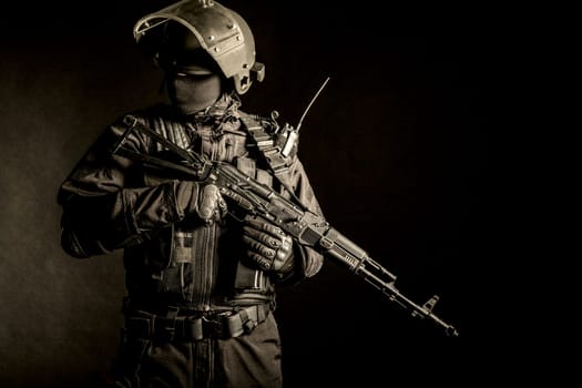 Russian special forces operator in black uniform and bulletproof helmet