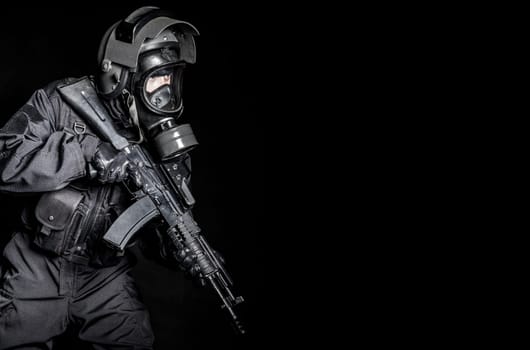 Russian special forces operator in black uniform and gas mask