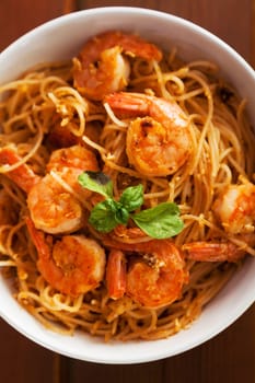 Thai rice noodles with shrimps in a bowl with chopsticks