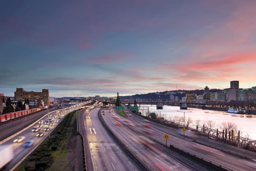 Portland Oregon rush hour traffic with city skyline along Interstate freeway during sunset evening