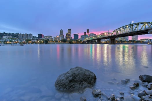 Portland Oregon downtown waterfront city skyline by Hawthorne Bridge along Willamette River at Twilight