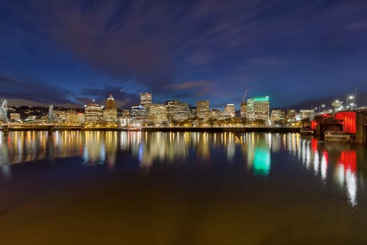 Portland Oregon downtown city skyline between Morrison Bridge and Hawthorne Bridge along Willamette River at Evening Blue Hour