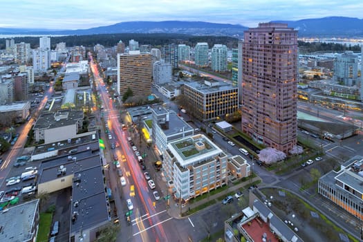 Vancouver British Columbia Canada Cityscape with Robson Street Light Trails and Stanley Park View at Dusk