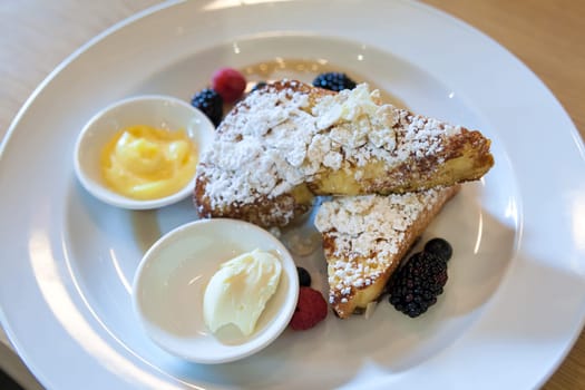 French Toast with Powdered Sugar Butter and Berries Closeup