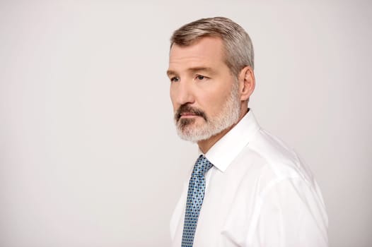 Portrait of a senior businessman isolated on grey background