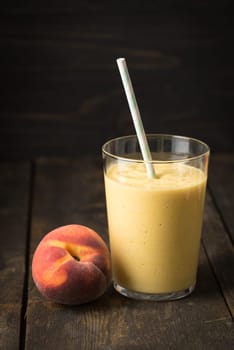 Orange healthy smoothie with yoghurt and peach in glass