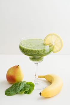 Green smoothie made from pear,banana,spinach and banana in glass