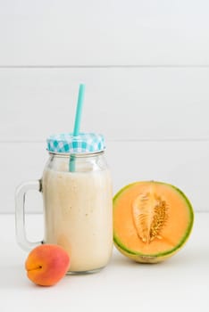 Orange healthy smoothie with yoghurt,apricot and melon in glass