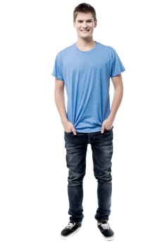 Smiling man posing with hands in pockets