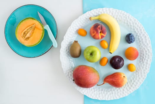 Collection of various fruits on a plate with sliced melon