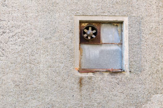 one old ventilation fan on the wall on a very old building