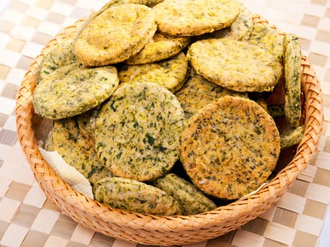 Homemade biscuits with spinach in a basket, close up