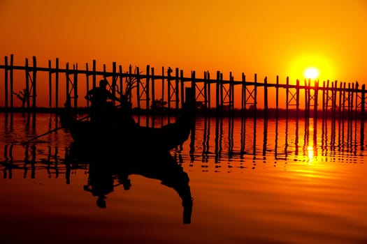 U Bein Bridge at sunset with people crossing Ayeyarwady River, Mandalay, Myanmar