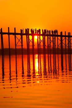 U Bein Bridge at sunset with people crossing Ayeyarwady River, Mandalay, Myanmar