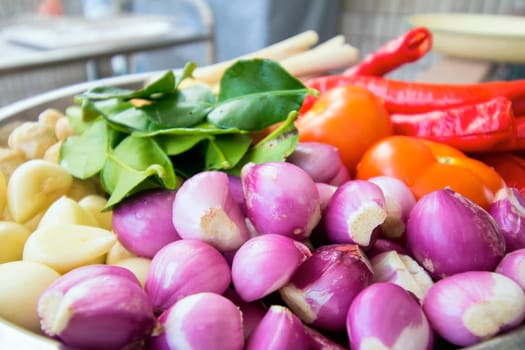 Fresh Ingredients for Cooking Southeast Asian Curry Dish Sauce with Shallots Chili Peppers Ginger Lemon Grass Onions Lime Leaves Garlic Candle Nut Tomato Closeup Macro