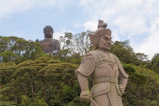 The General Makura of the Twelve Divine Generals at Ngong Ping Village with Tian Tan Big Buddha in the Background