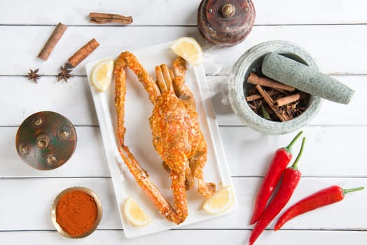 Top view cooked delicious hot and spicy sauce blue crab and ingredients, on wood background. Fresh cook with hot smoke steams.