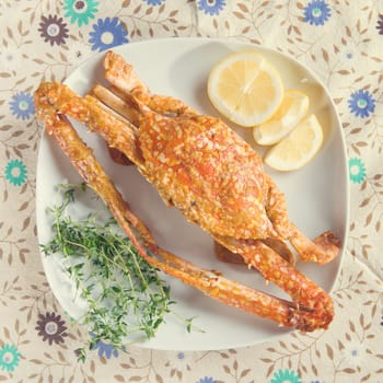 Top view cooked delicious hot and spicy sauce blue crab on white plate with vintage tone.