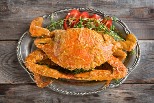 Above view cooked delicious hot and spicy sauce blue crab, on wooden background. Fresh cook with hot smoke steams.