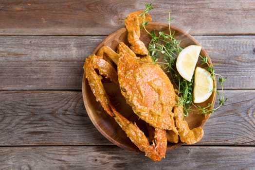 Top view cooked delicious hot and spicy sauce blue crab, on wooden background. Fresh cook with hot smoke steams.