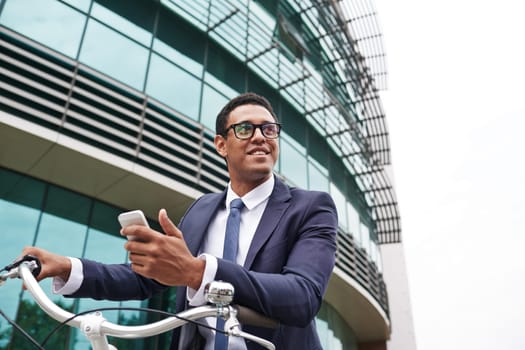 Happy businessman with cellphone on background of modern building