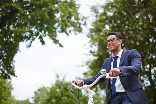 Young businessman riding on bicycle after working day