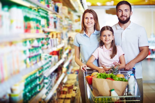 Caucasian family looking at camera in modern hypermarket