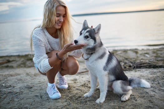 Pretty girl spending summer vacation by the seaside with her dog