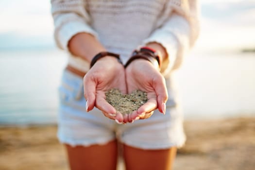 Close-up of girl holding sand on her palms