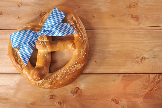 original Bavarian giant folk festival breze with Bavarian flag on wooden boards